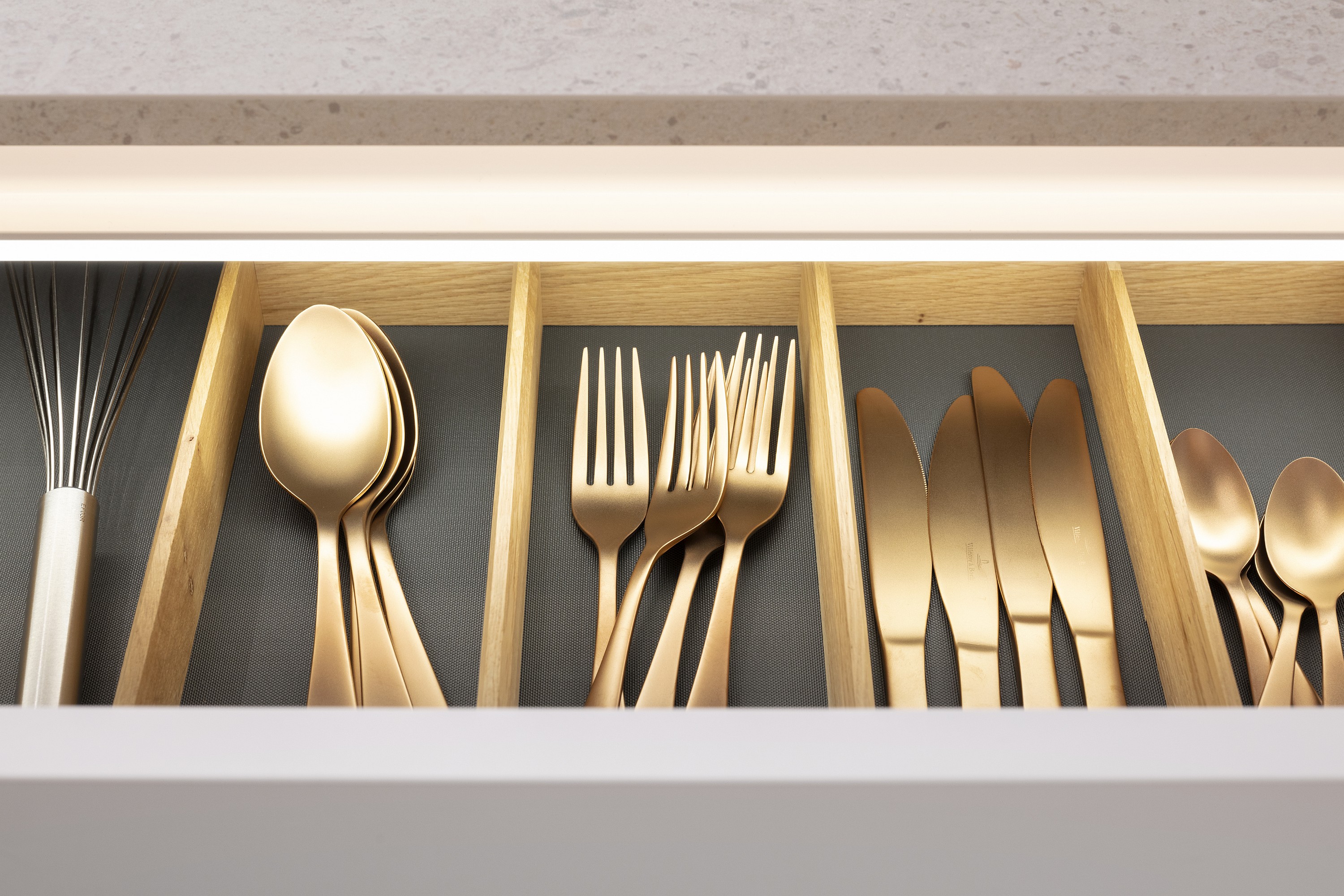 Goldenes Besteck in einer halb geöffneten Besteck-Schublade in einer Nobilia Küche
